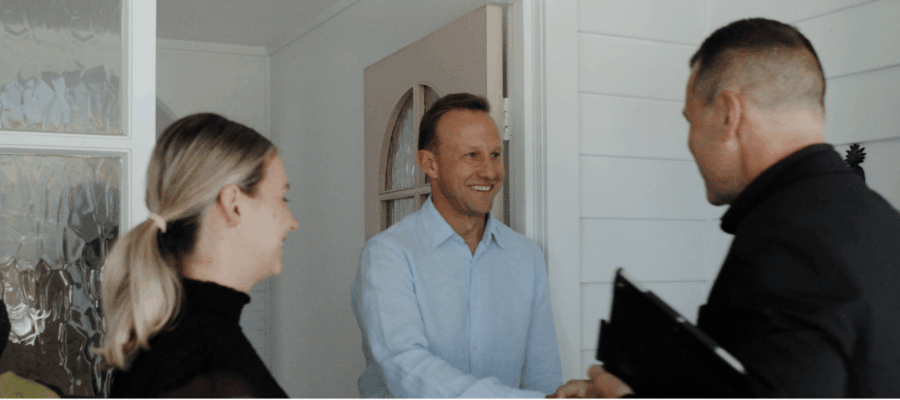 Sales agent welcoming open home attendees to a property inspection