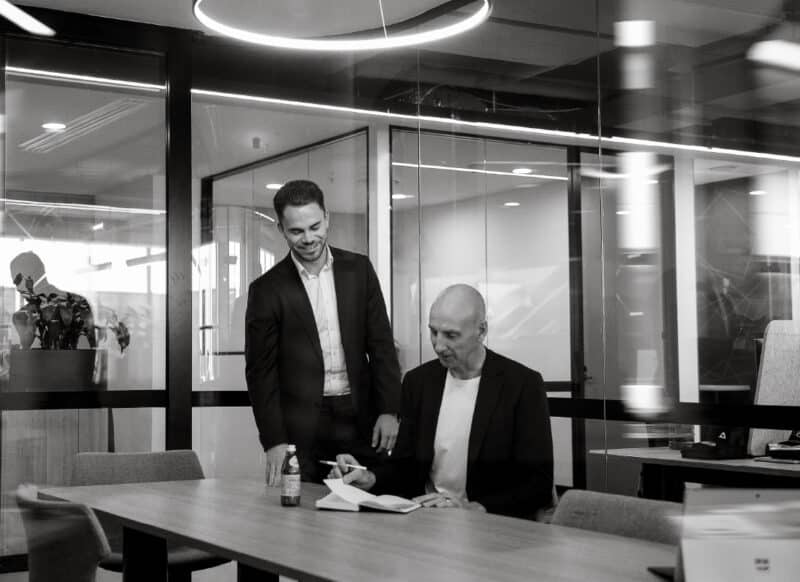 Commercial sales professionals working through plans and documents in a strategic meeting.