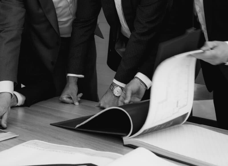 Experienced commercial agents collaborating around a table during a property sales discussion.