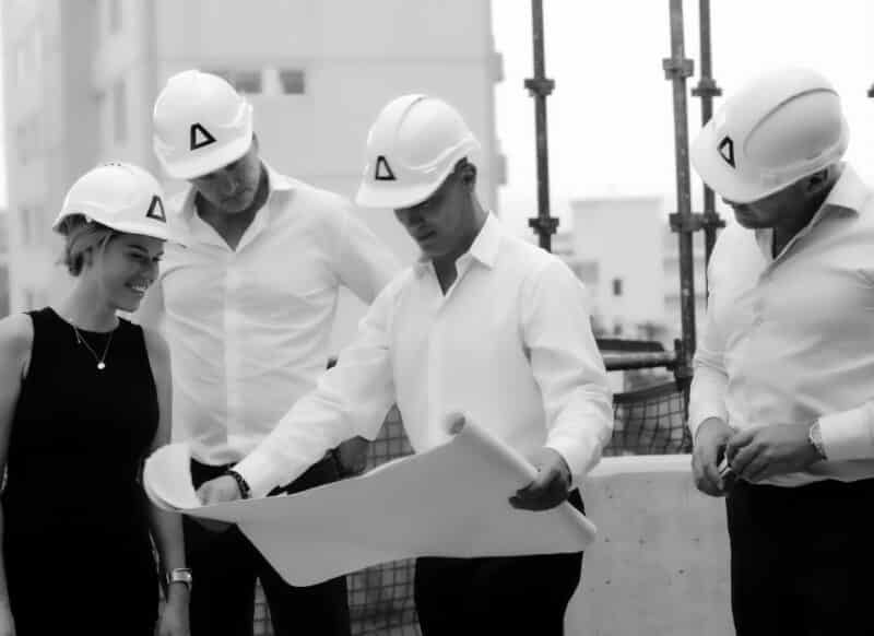 Development team reviewing architectural plans on site