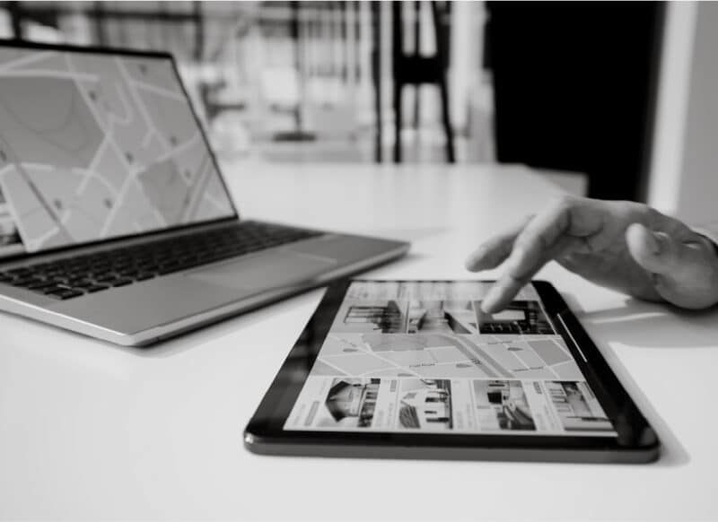 Tablet and laptop displaying property listings and mapping tools used in project sales strategy.
