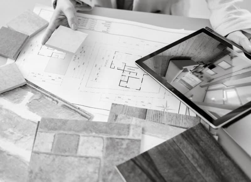 Material samples and floor plans reviewed alongside a digital property layout, illustrating Upstate’s considered and efficient process